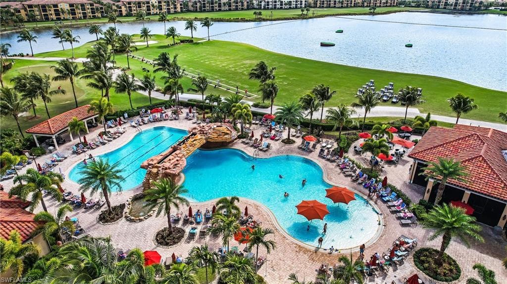 Community pool featuring golf course view, a water view, and a patio area