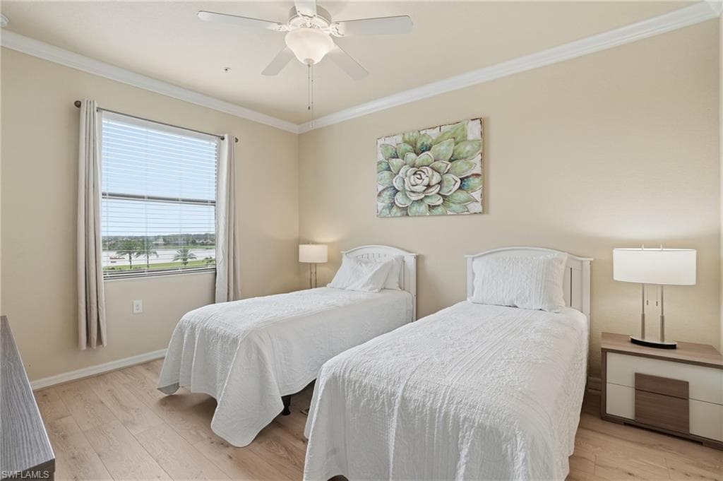 Bedroom featuring light wood-style flooring, crown molding, and a ceiling fan