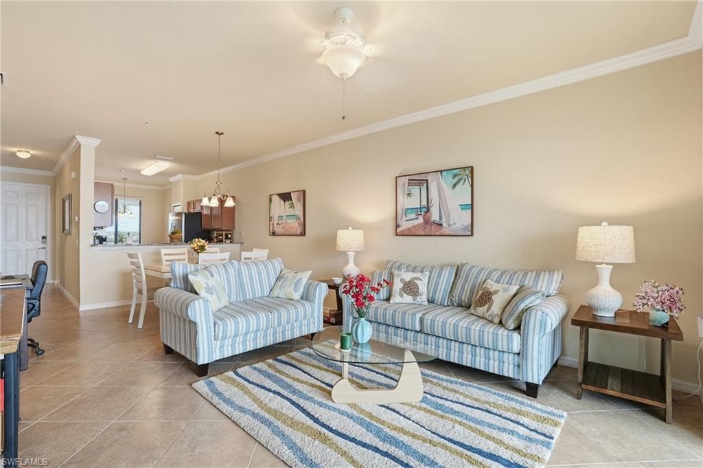 Living area with crown molding, light tile patterned flooring, and ceiling fan