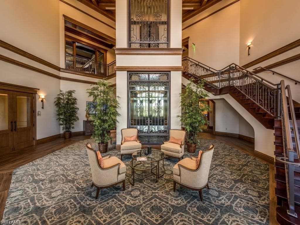 Community lobby featuring stairway, a high ceiling, and crown molding