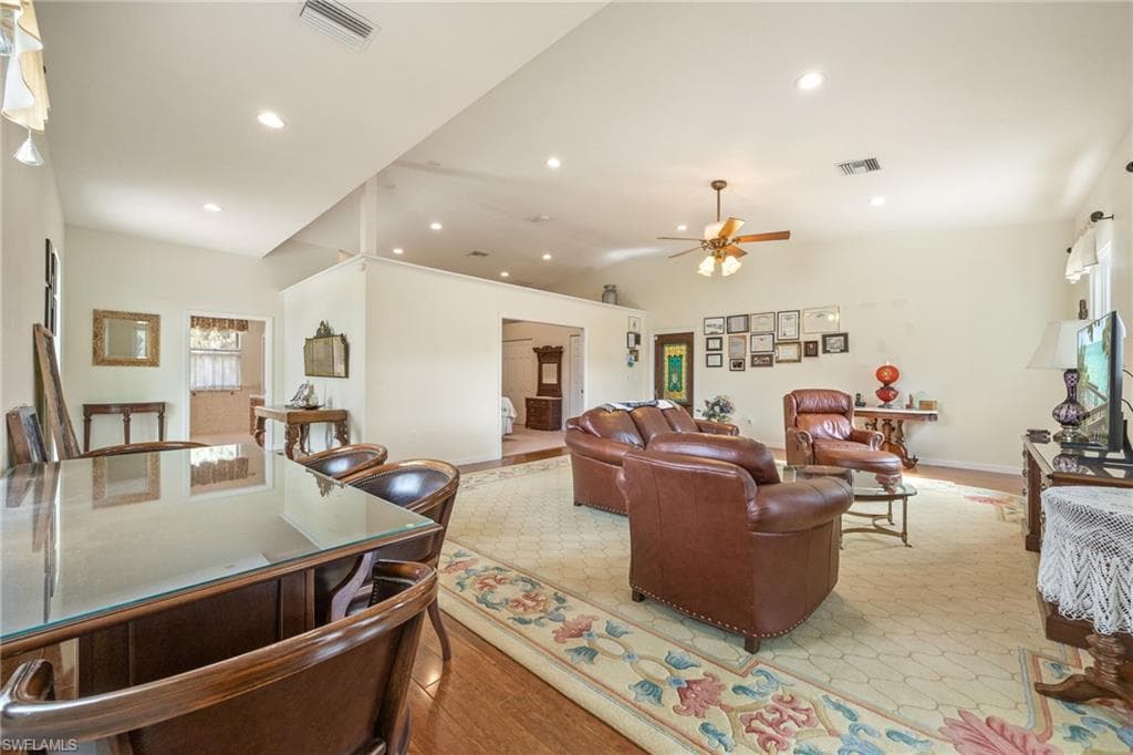 Living area featuring vaulted ceiling, light wood finished floors, recessed lighting, and ceiling fan
