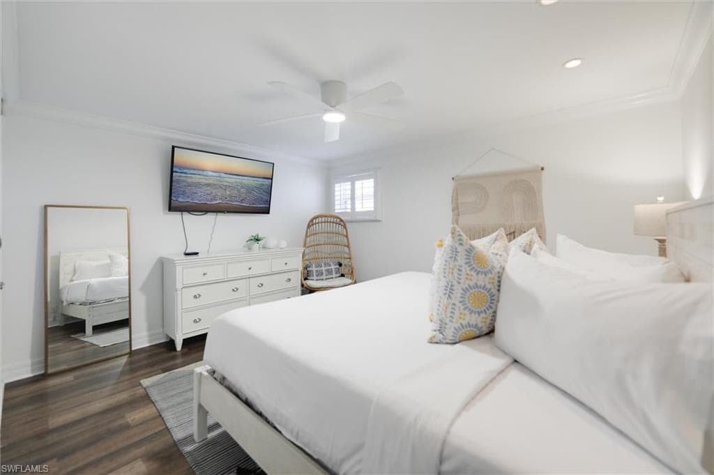 Bedroom with crown molding, dark wood-style floors, and ceiling fan
