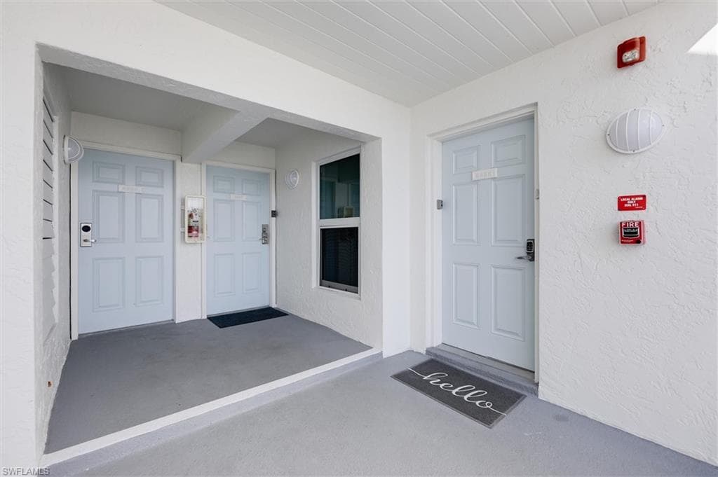 View of exterior entry with a porch and stucco siding