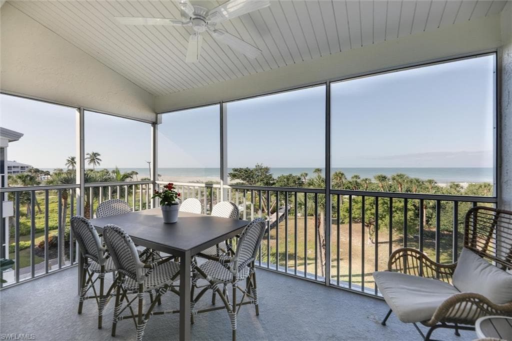 Sunroom with a water view, plenty of natural light, vaulted ceiling, wooden ceiling, and carpet floors