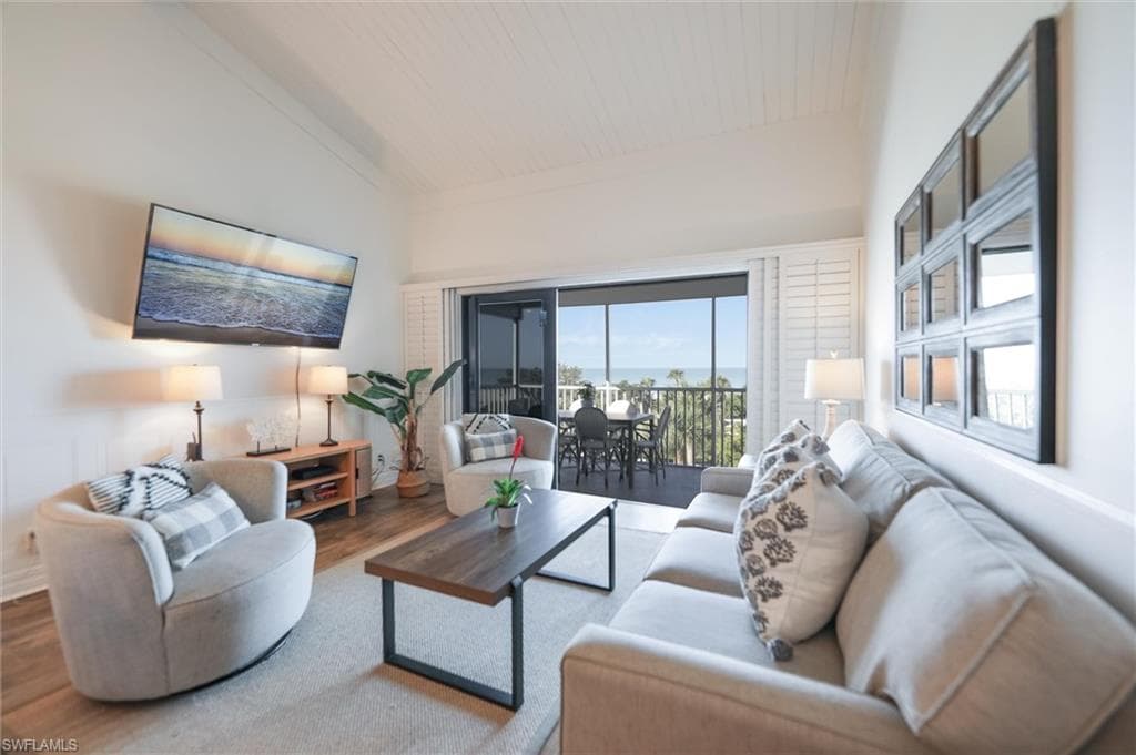 Living room featuring lofted ceiling, wood finished floors, and wood ceiling