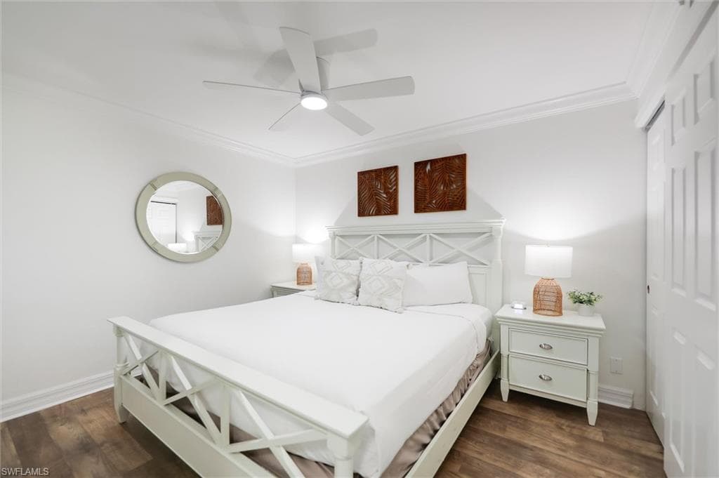 Bedroom featuring crown molding, a closet, dark wood-type flooring, and a ceiling fan