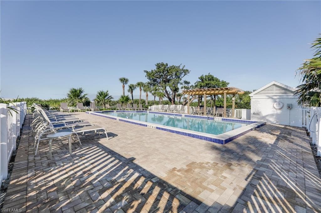 Community pool featuring a patio area and a pergola