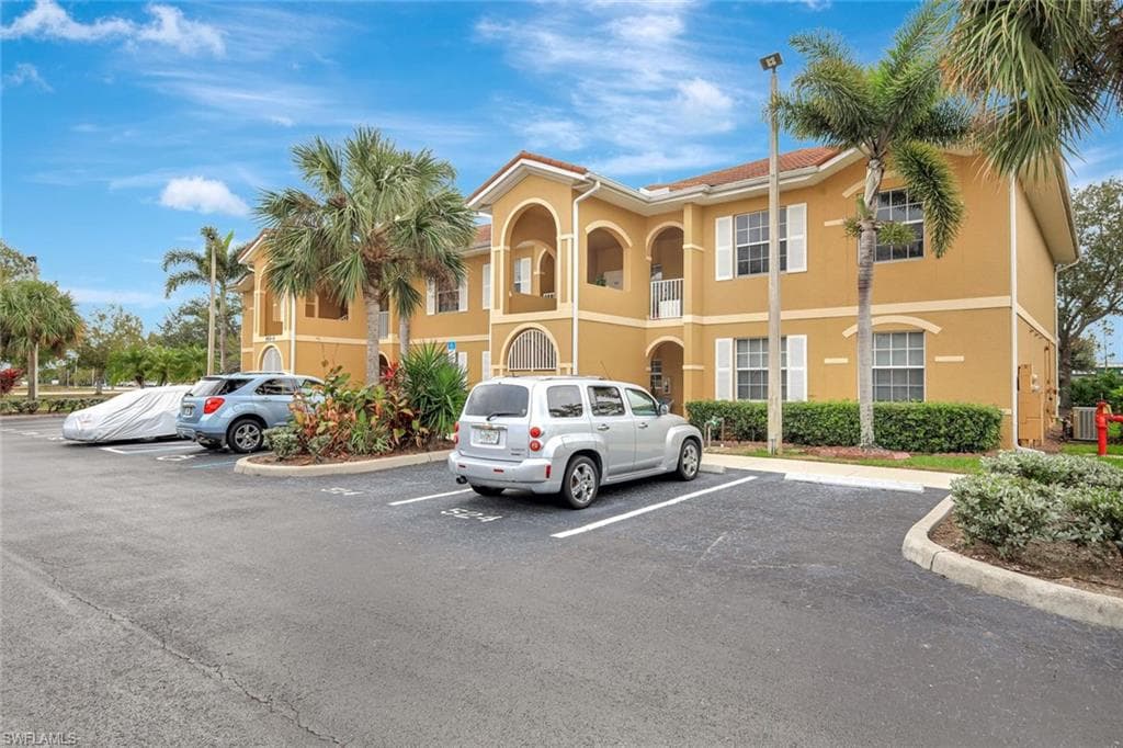 View of apartment building / complex with uncovered parking