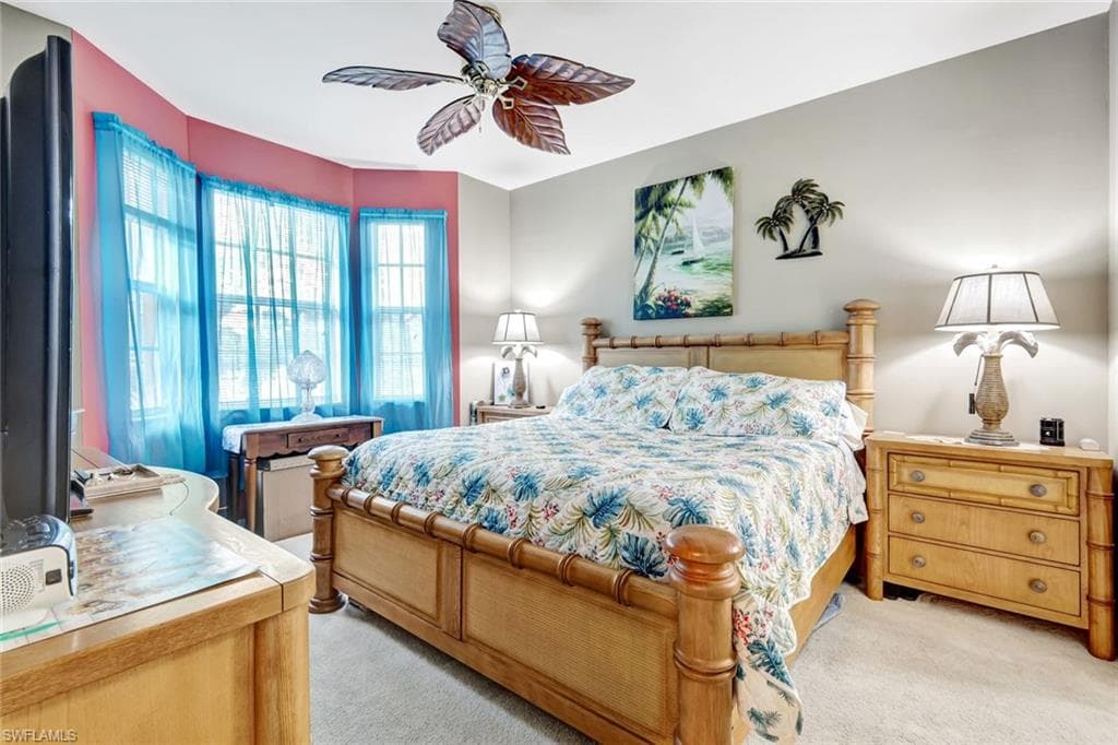 Bedroom with light colored carpet and a ceiling fan