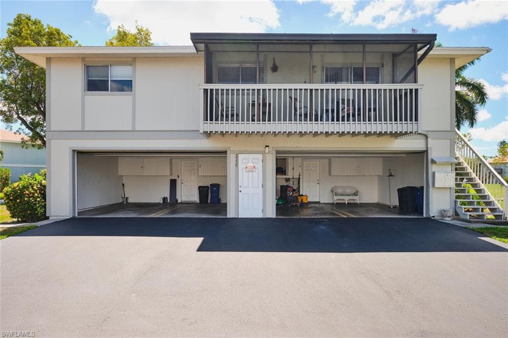 View of front of property with stairway, driveway, and a garage