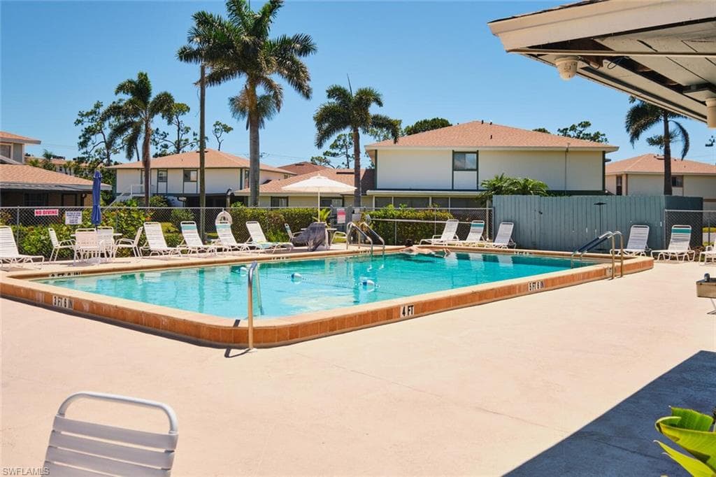 Community pool with a patio area and a residential view