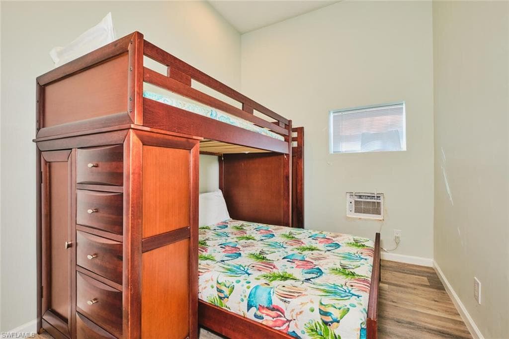 Bedroom 1 of apartment on first level with baseboards and light wood finished floors