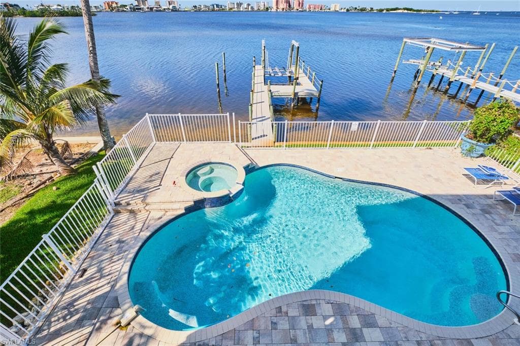 Main living area - View of swimming pool with a water view, a pool with connected hot tub, a patio, and a view of city