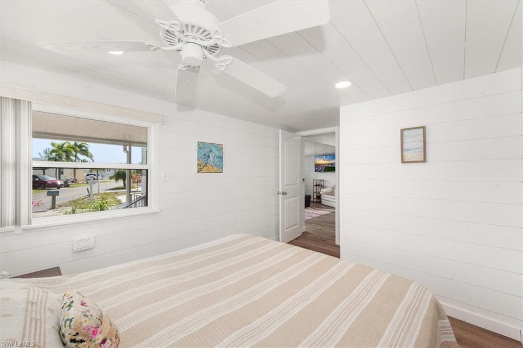 Bedroom with recessed lighting, wood walls, and wood finished floors