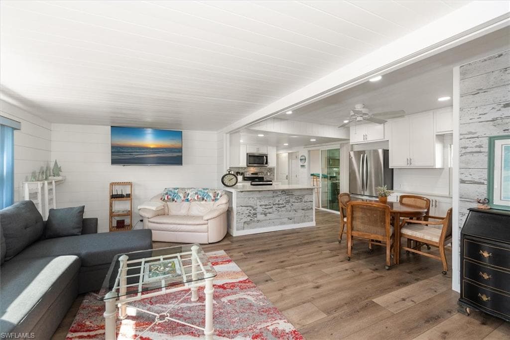 Living room featuring light wood-style flooring, recessed lighting, and ceiling fan