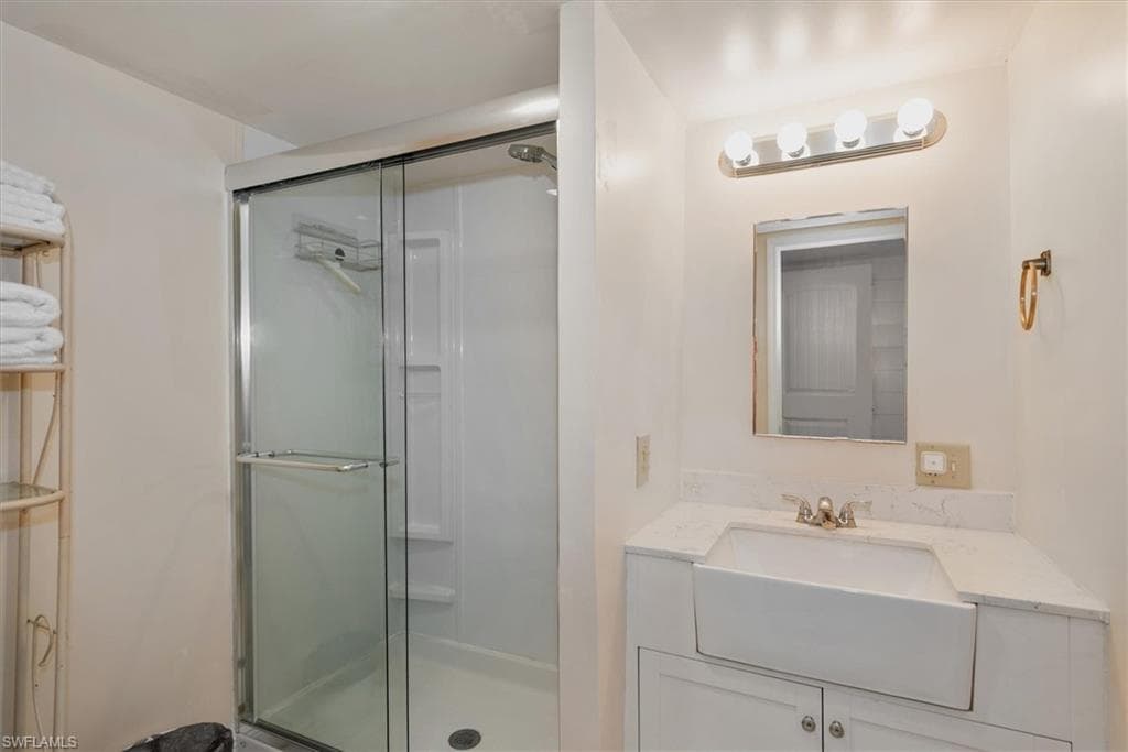 Full bath featuring vanity and a shower stall