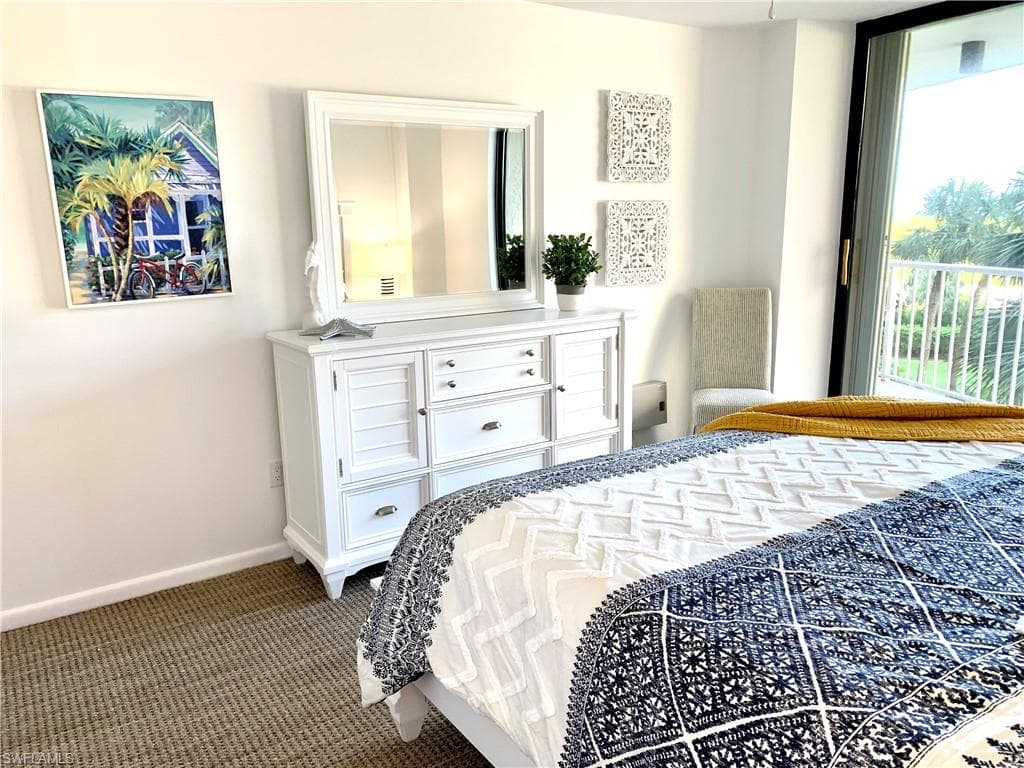 Bedroom featuring dark colored carpet and baseboards
