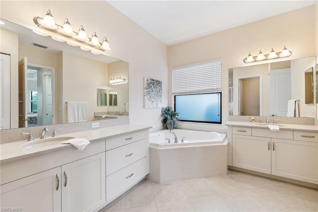 Primary ensuite bathroom with dual countertops, soaking tub