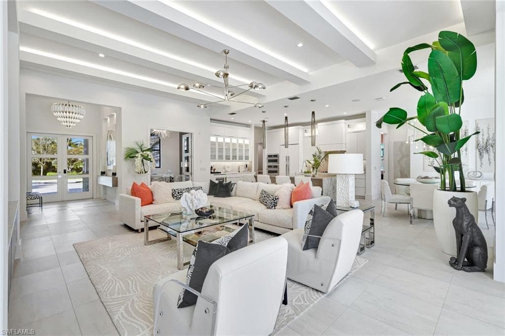 Living room with a chandelier, french doors, healthy amount of natural light, beamed ceiling, and recessed lighting