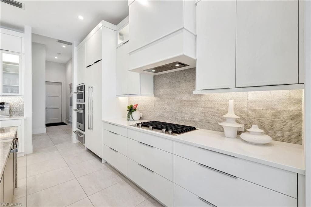 Kitchen featuring glass insert cabinets, modern cabinets, white cabinets, and recessed lighting