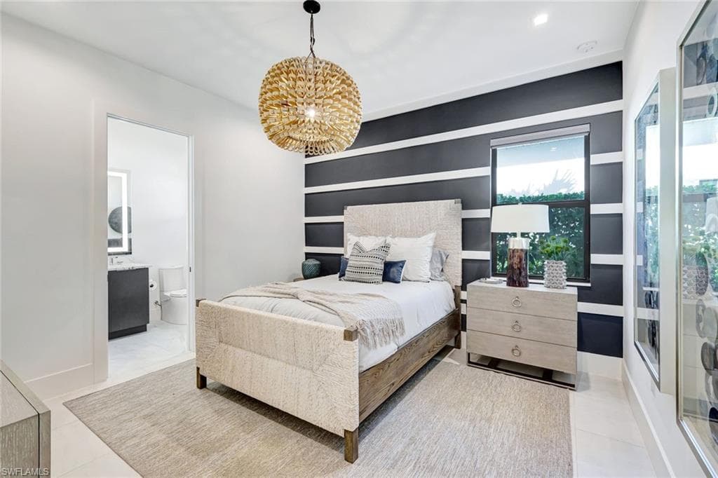 Bedroom with ensuite bathroom, a chandelier, and light tile patterned floors
