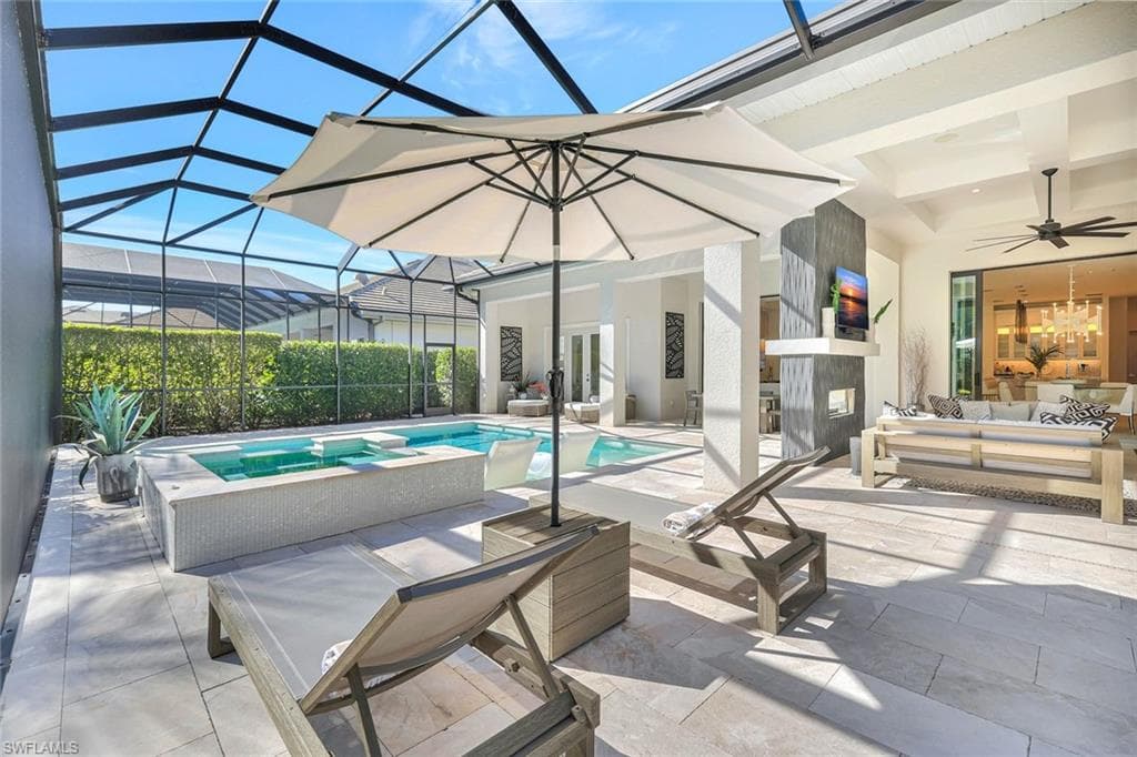 View of swimming pool featuring glass enclosure, a patio, a sunroom, and outdoor lounge area