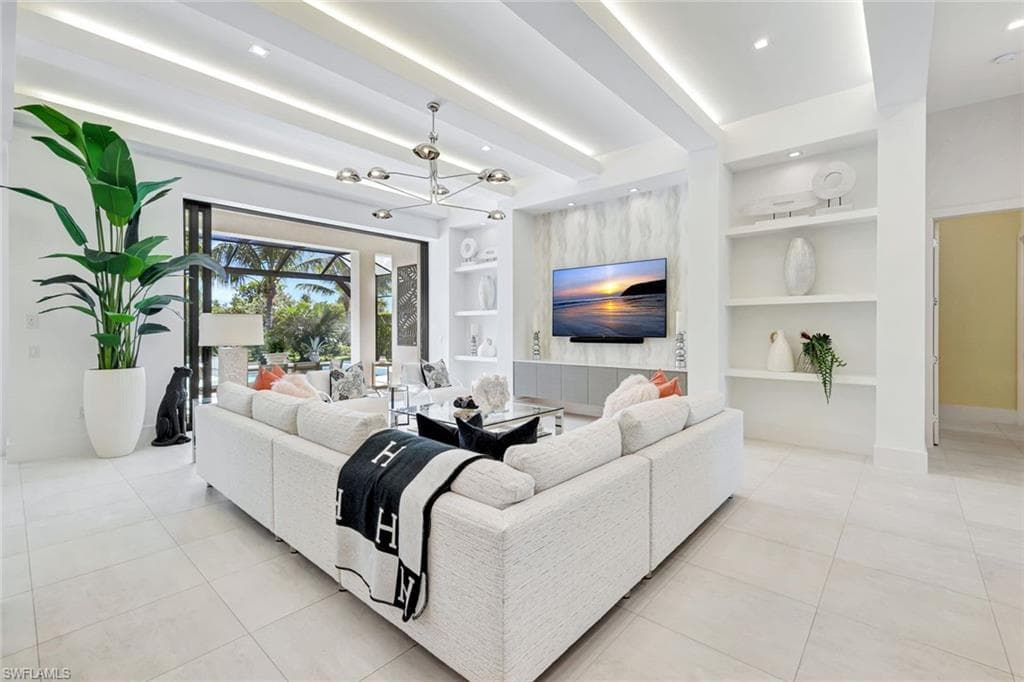 Living area featuring built in features, a chandelier, beam ceiling, light tile patterned flooring, and recessed lighting