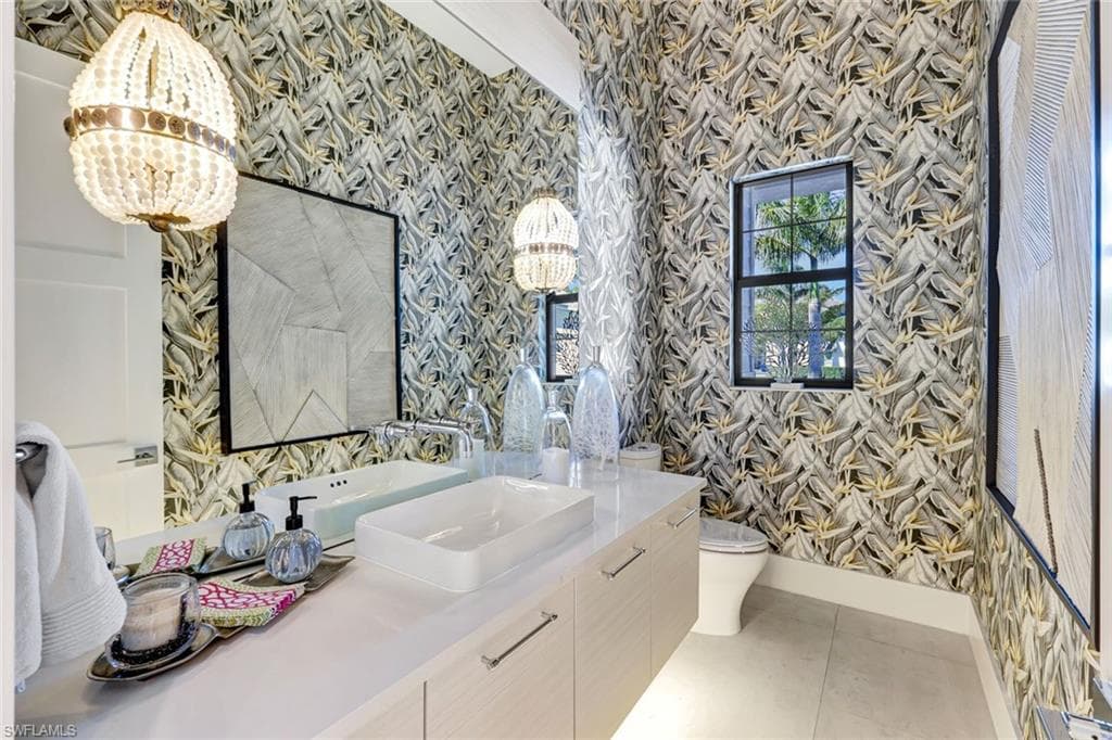 Bathroom featuring wallpapered walls and vanity