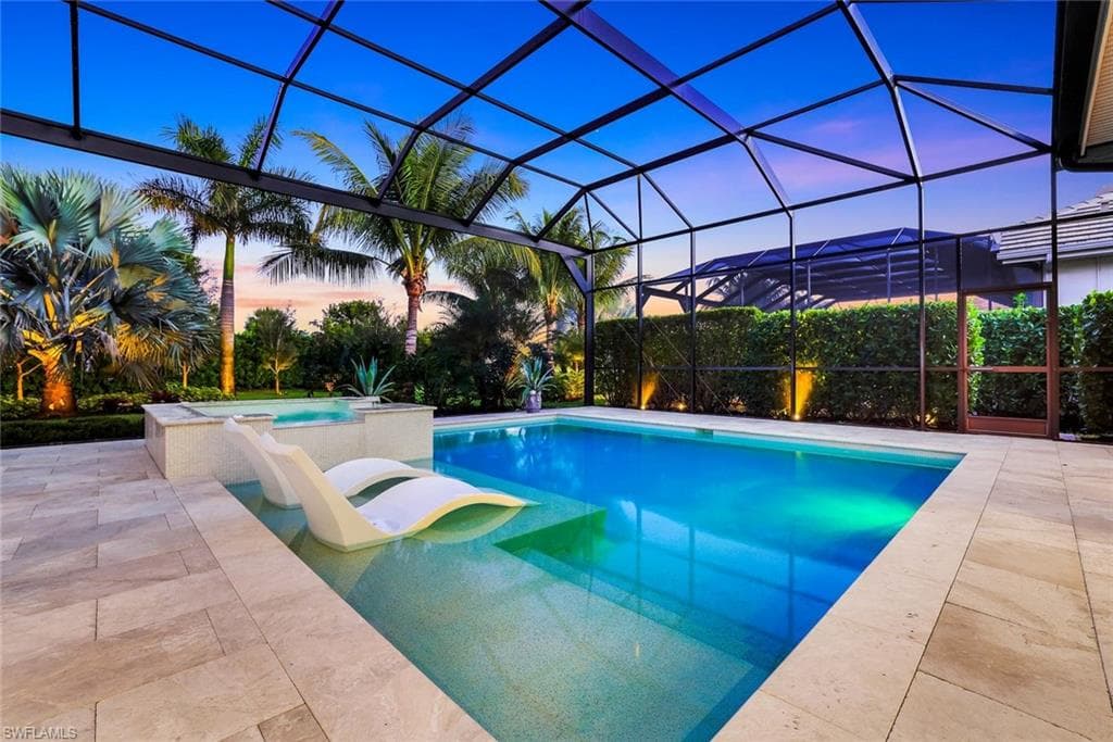 Swimming pool with an in-ground hot tub, a lanai, a sunroom, and a patio