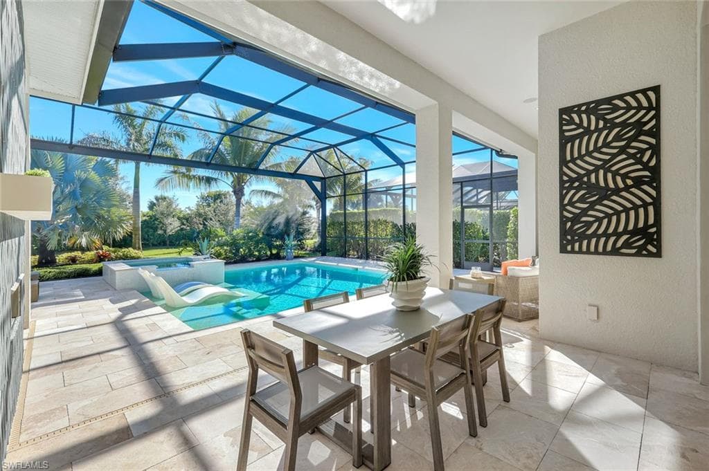 View of pool with a patio, a sunroom, a lanai, a pool with connected hot tub, and outdoor dining space