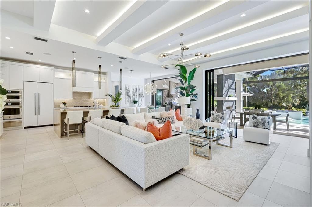 Living area with a chandelier, beam ceiling, recessed lighting, and light tile patterned floors