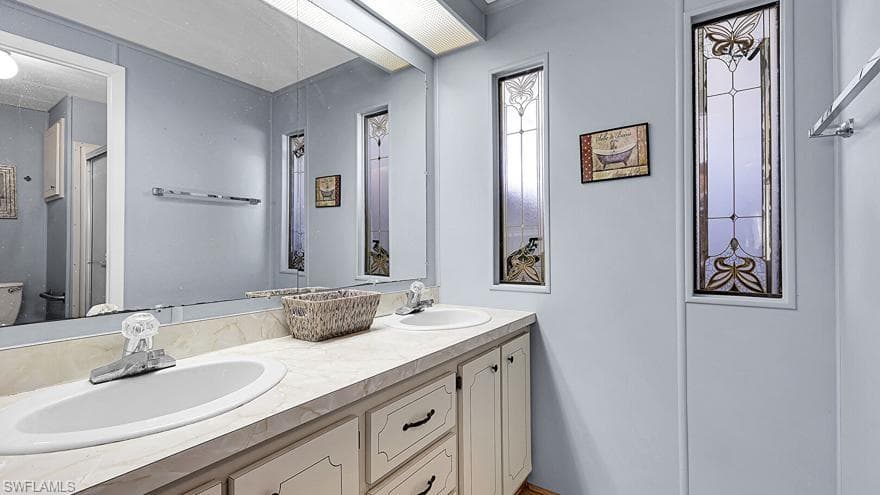 Bathroom featuring double vanity and toilet