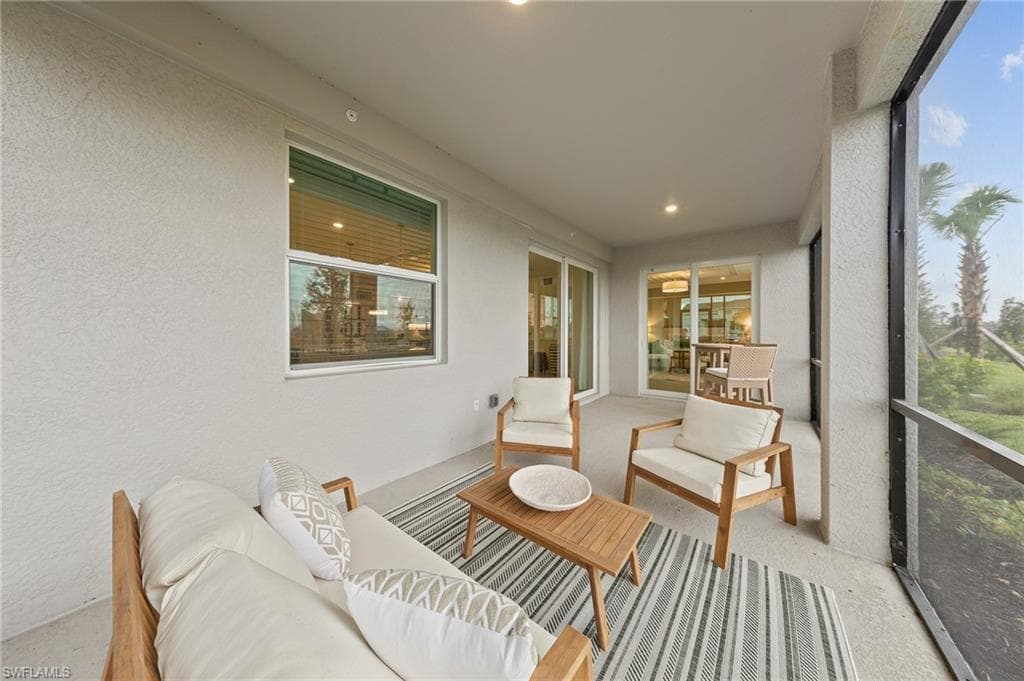 Sunroom featuring a textured wall, an outdoor living space, and recessed lighting