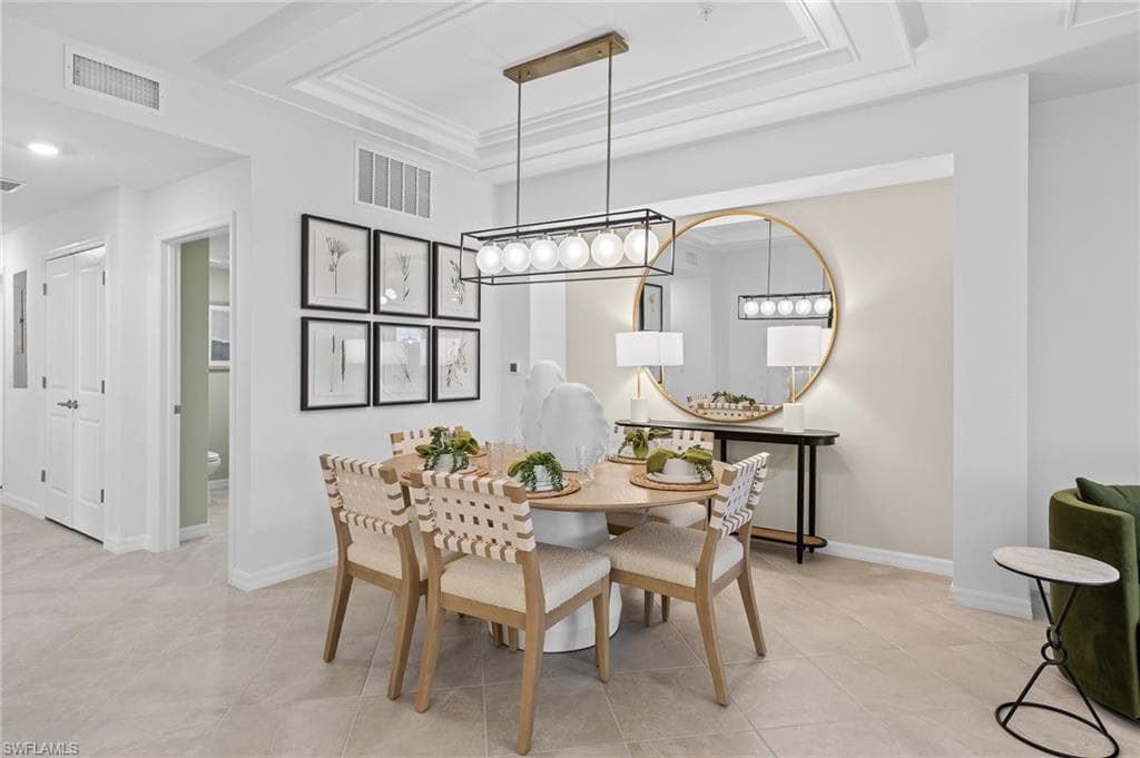 Dining room with a tray ceiling and light tile patterned floors