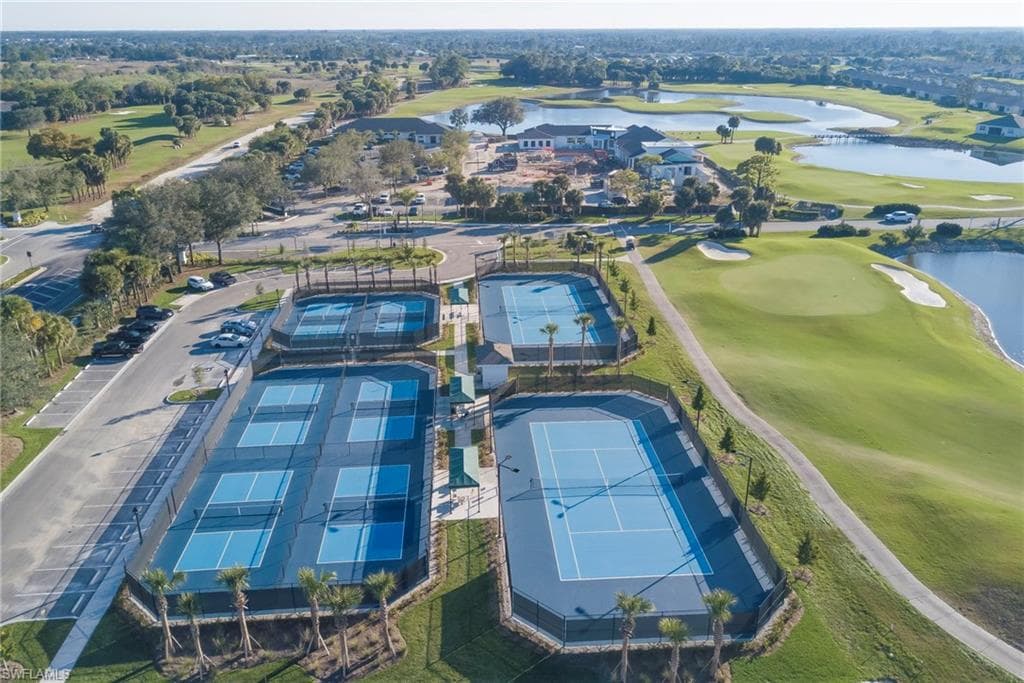 Aerial view of property and surrounding area with a local golf course and a nearby body of water