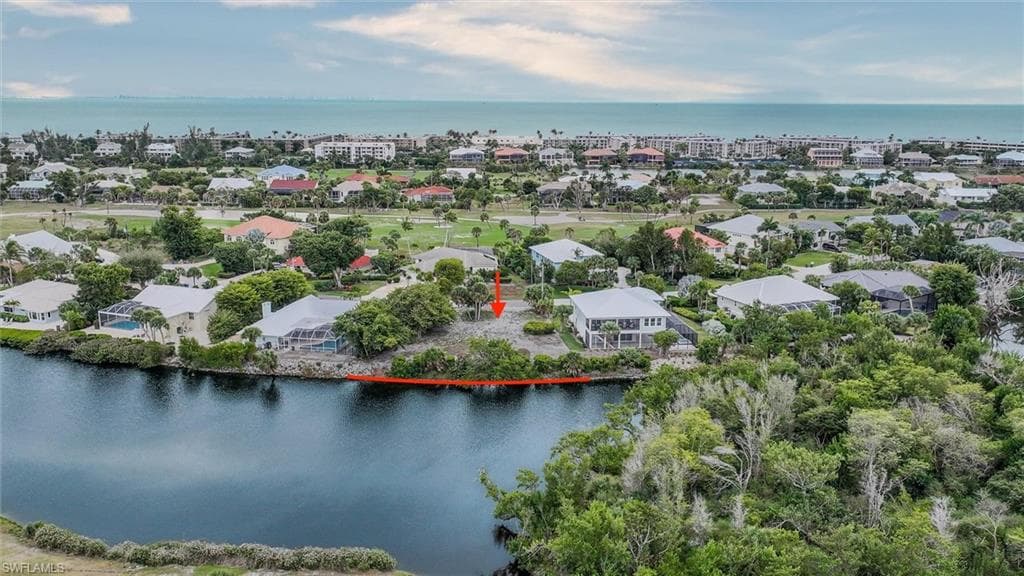 Aerial view of property and surrounding area with a nearby body of water