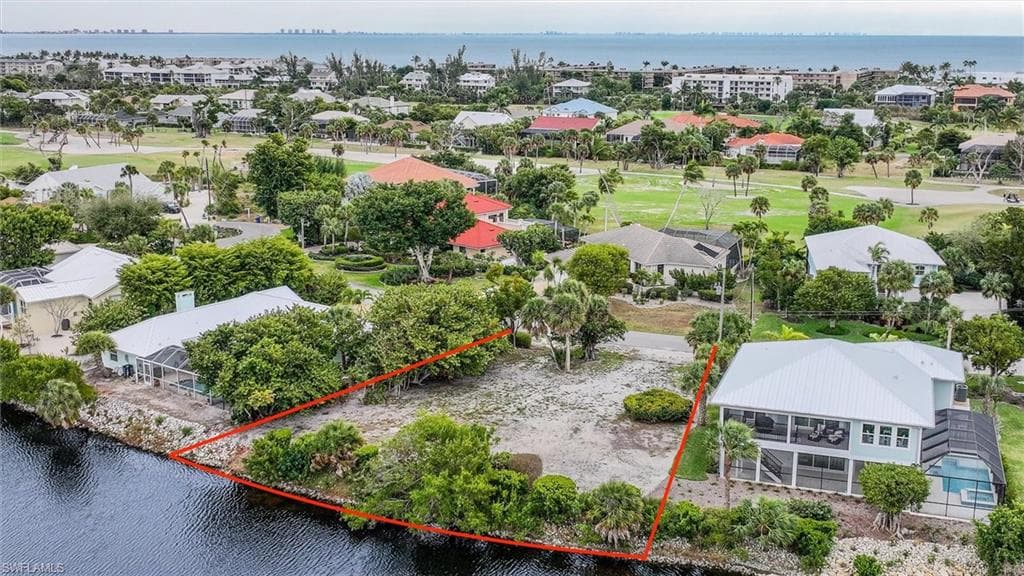 Aerial perspective of suburban area with a large body of water and property parcel outlined