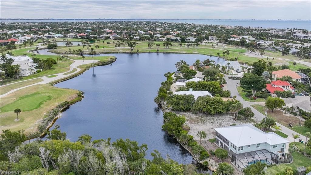 Aerial overview of property's location featuring a large body of water, a local golf course, and nearby suburban area