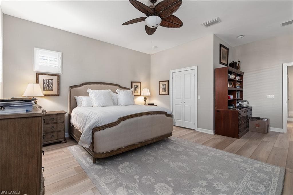 Bedroom featuring light wood-type flooring, a closet, and a ceiling fan