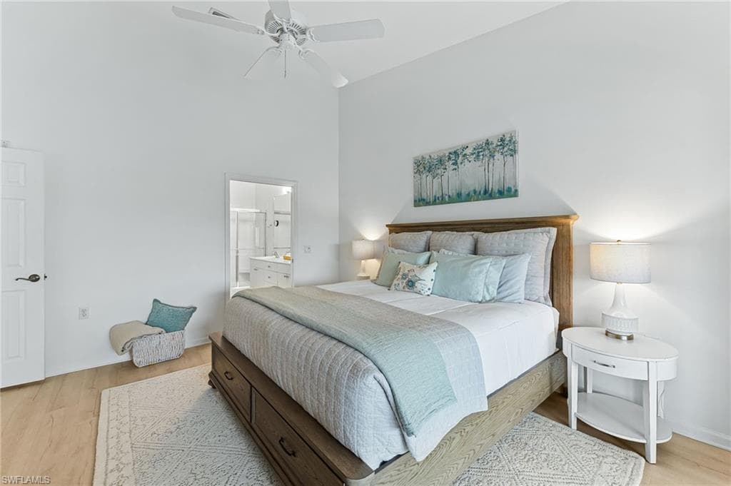 Bedroom featuring light wood-style flooring, ceiling fan, a high ceiling, and ensuite bathroom