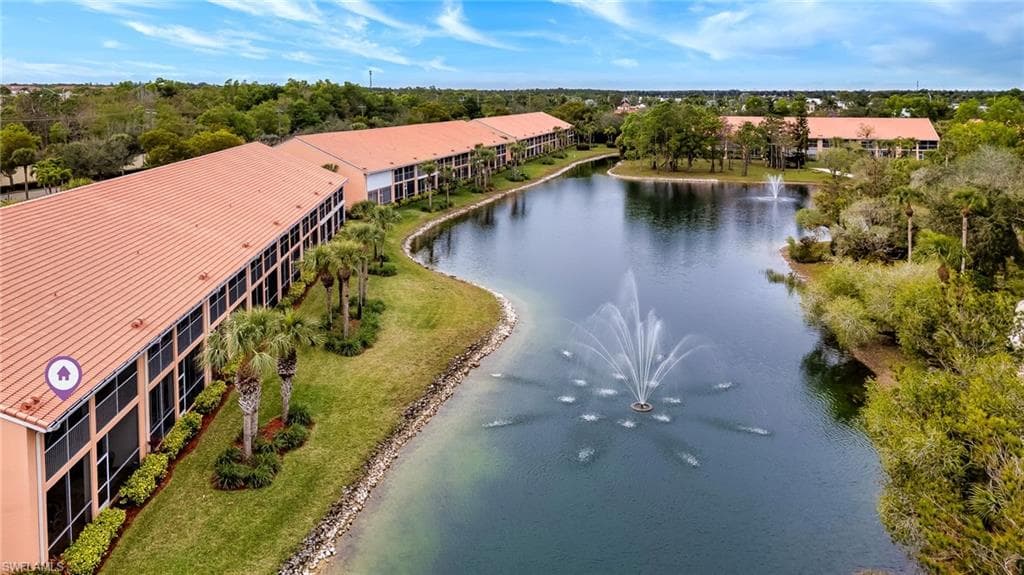 Drone / aerial view of a nearby body of water and a tree filled landscape