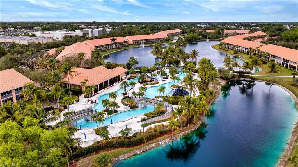 Drone / aerial view of a nearby body of water and a pool area