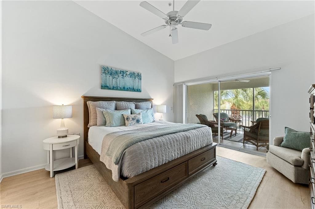 Bedroom featuring high vaulted ceiling, access to outside, light wood-style floors, and a ceiling fan