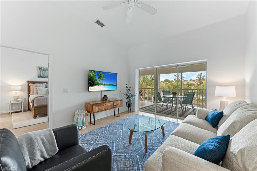 Living area featuring high vaulted ceiling and ceiling fan
