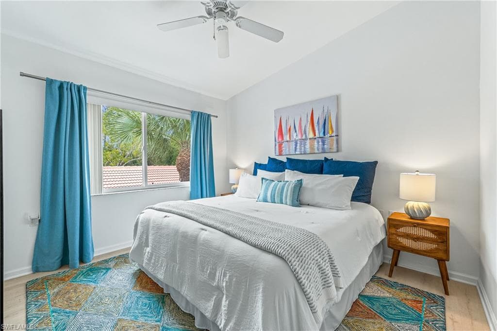 Bedroom featuring lofted ceiling, light wood-style flooring, and ceiling fan