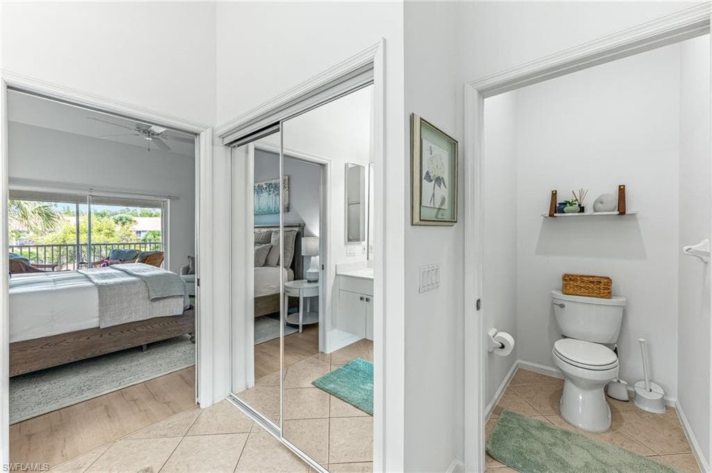 Bathroom with ensuite bathroom, vanity, light tile patterned floors, and ceiling fan