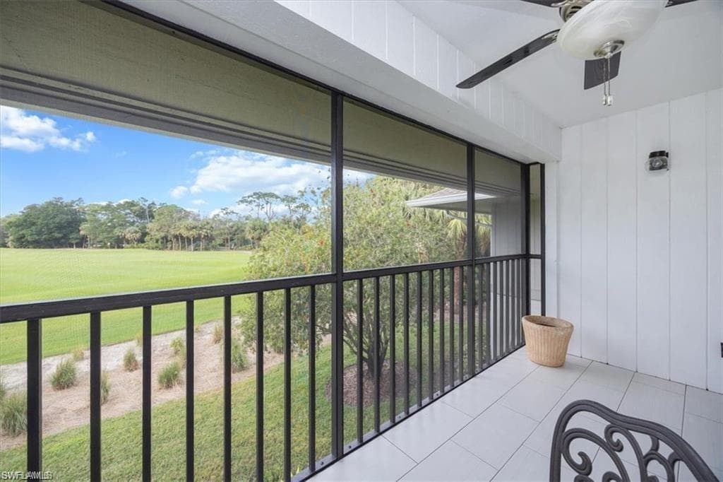 Balcony with a sunroom, a ceiling fan, and golf course view