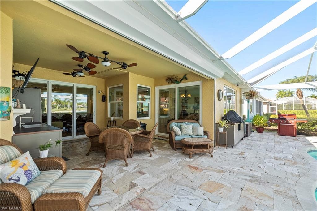 View of patio / terrace featuring an outdoor hangout area, grilling area, a ceiling fan, and a lanai