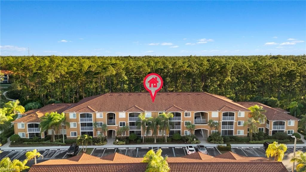 Drone / aerial view of a heavily wooded area and apartment complex / building