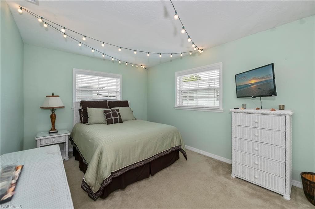 Bedroom with multiple windows and light carpet